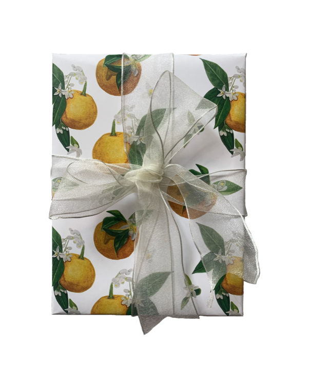 A gift is wrapped in the Orange Blossom Wrapping Paper and tied with a translucent white ribbon. 
